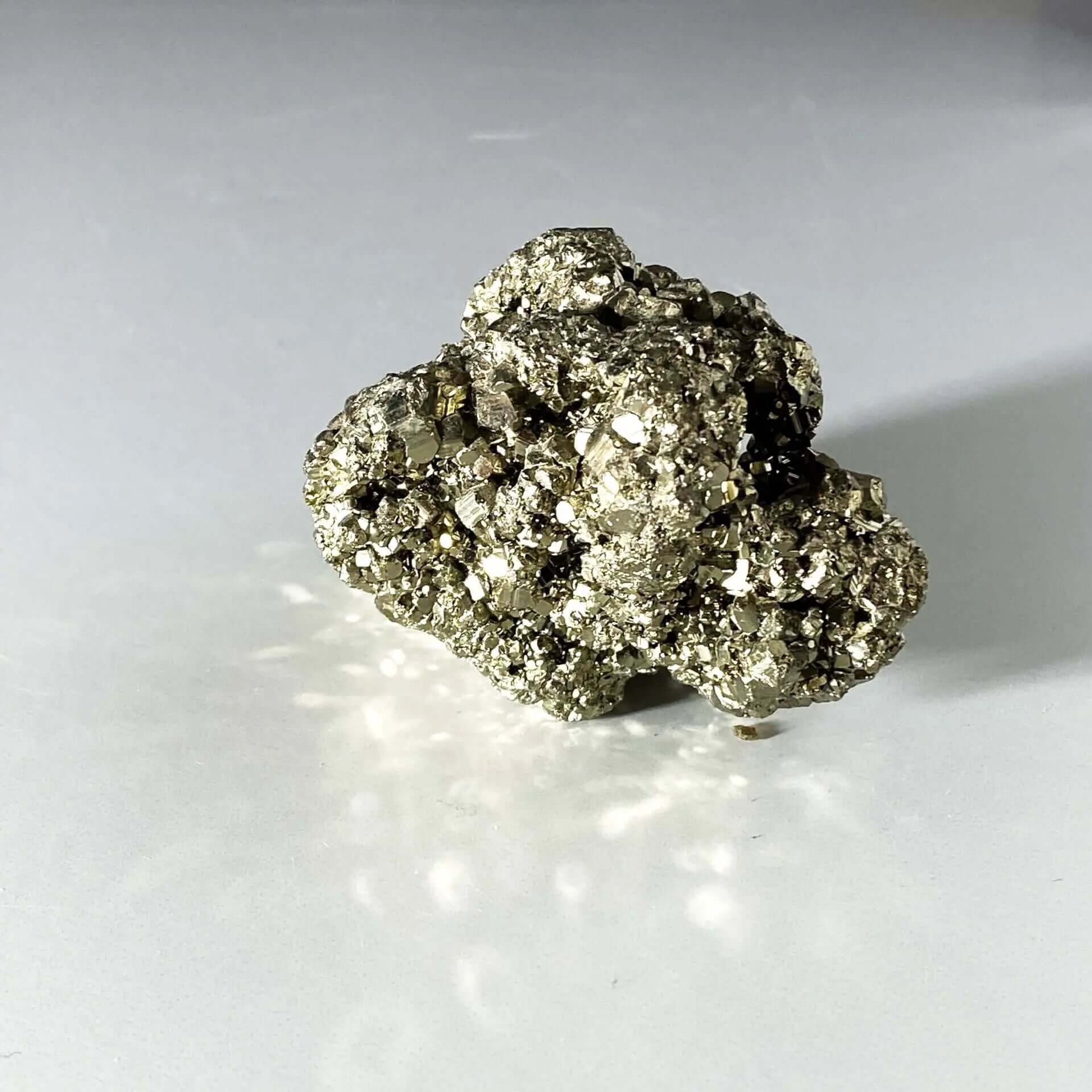 Pyrite on white background with dramatic shadow