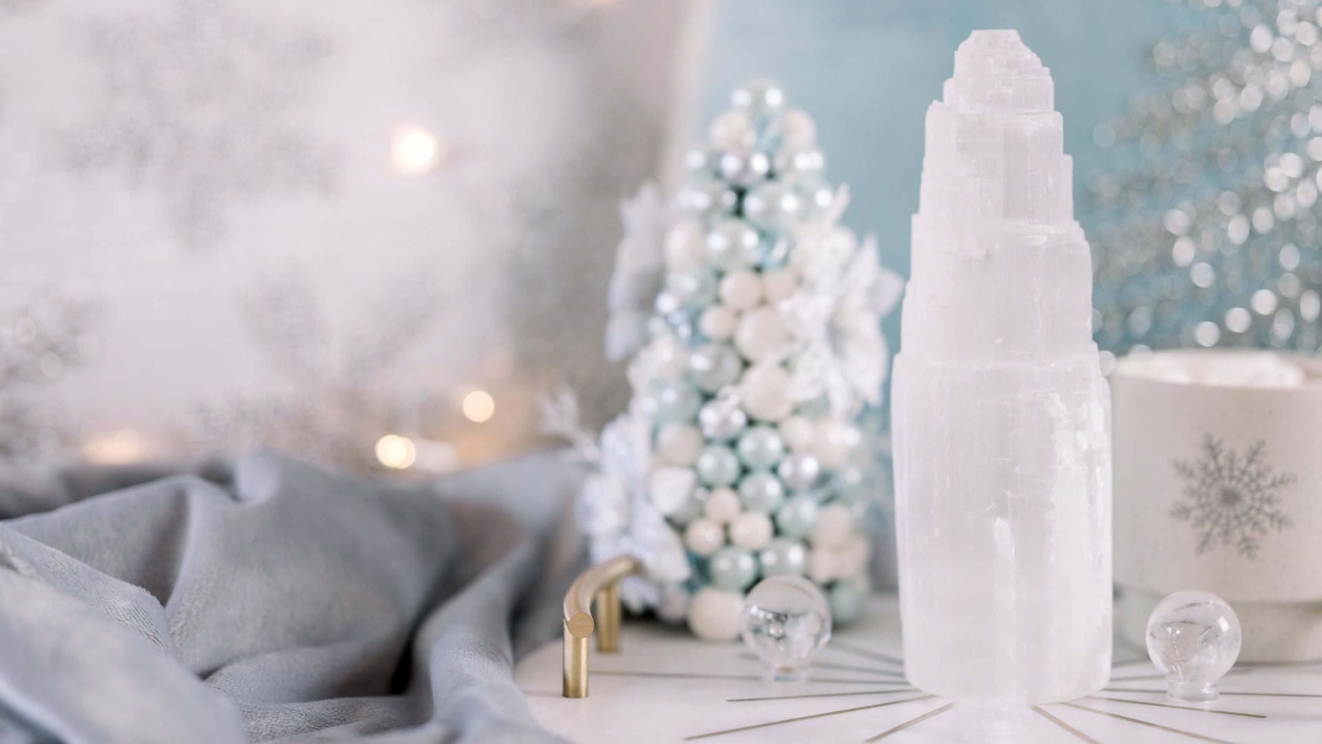 A Christmas holiday scene with pastel ornaments, a selenite tower, and a mini Christmas tree