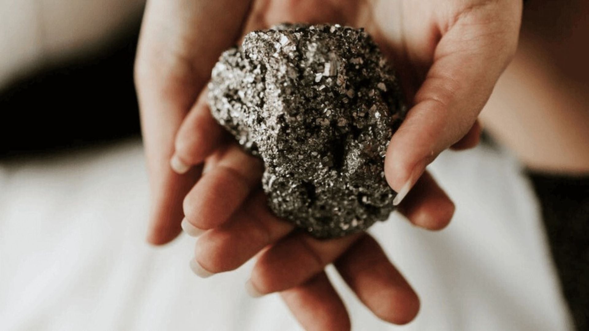 woman holding a pyrite crystal