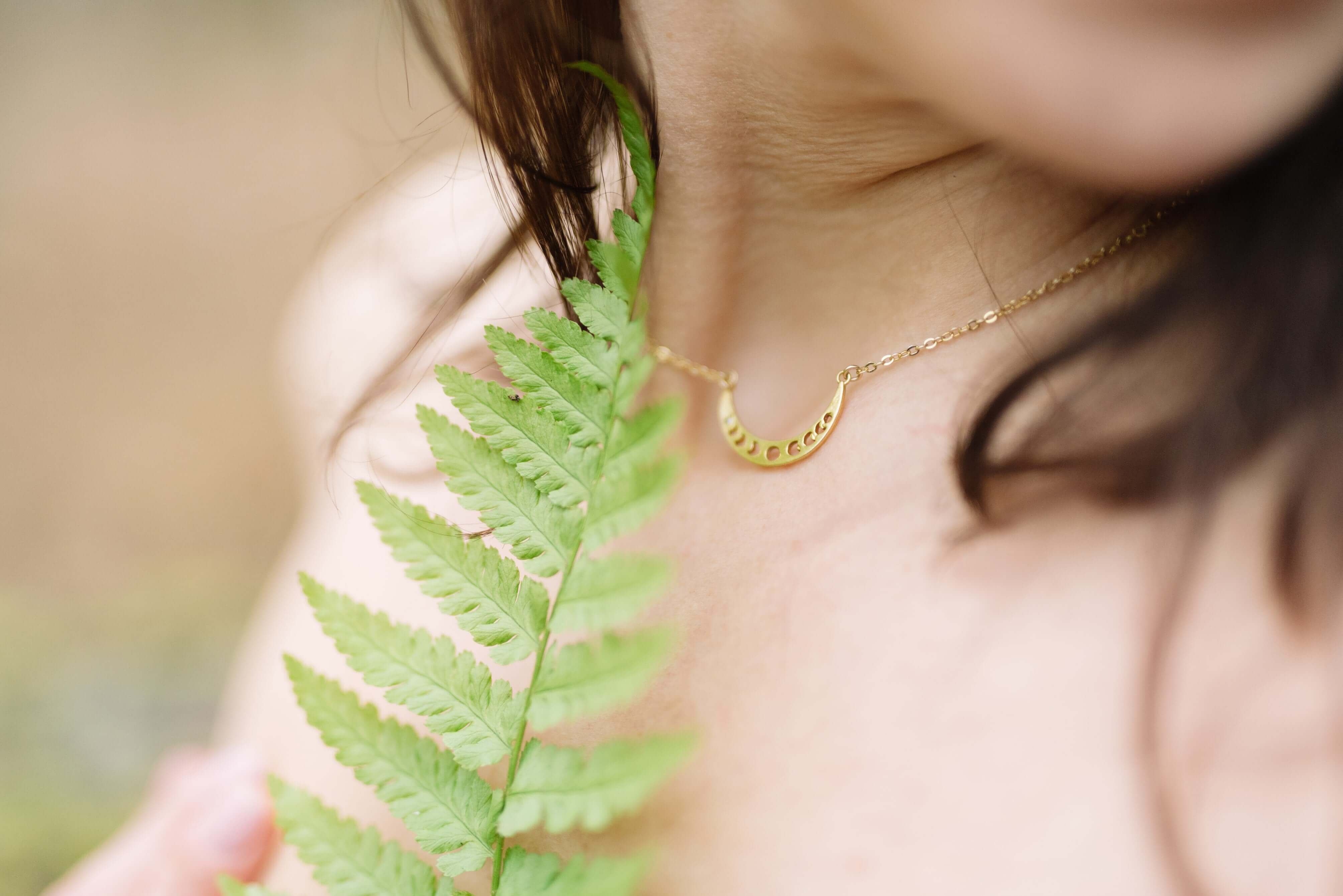 A woman's neckline with a fern leaf. 