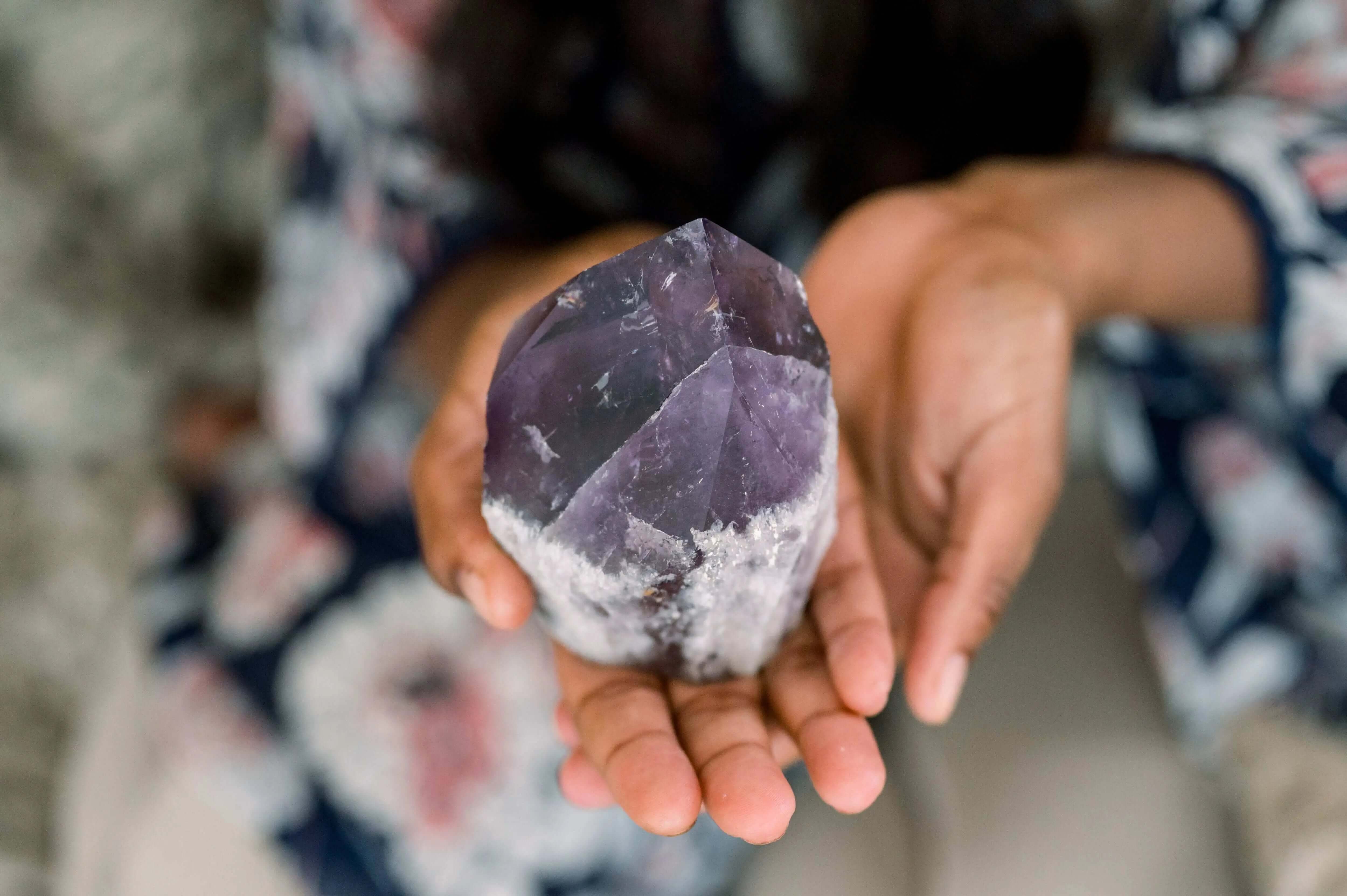 A woman holding an amethyst crystal in her hands