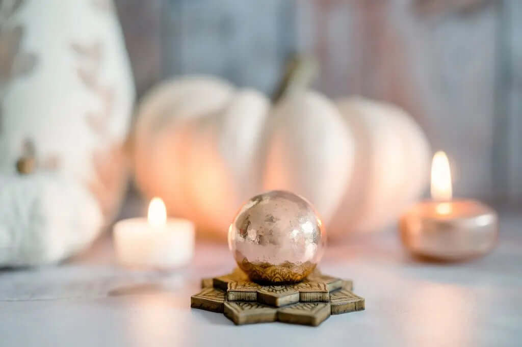 Indoor fall scene with a pumpkin, candle, and crystals