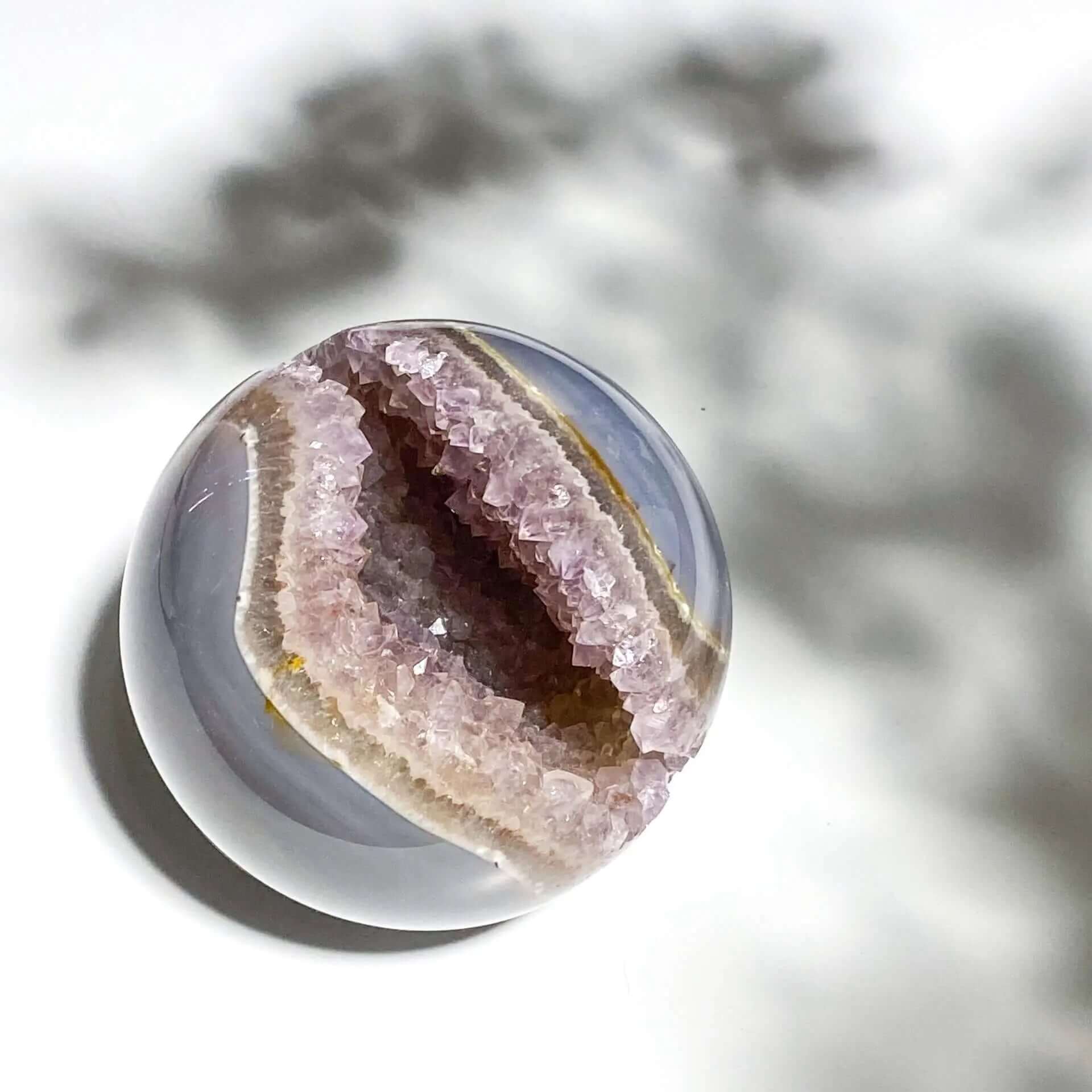 Amethyst geode on white background with dramatic shadow