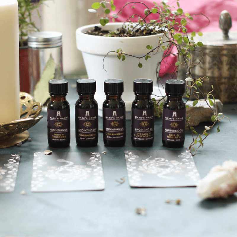 Several bottles of essential oils with flowers and crystals in the background